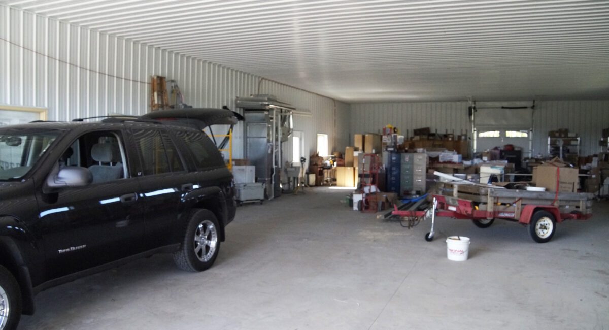 RAM 18-421 Garage space with a vehicle, storage boxes, and trailer