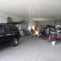 RAM 18-421 Garage space with a vehicle, storage boxes, and trailer