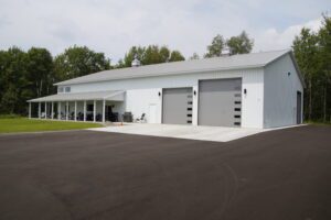 RAM 22-377 Left front view of building showing large double garage doors and driveway